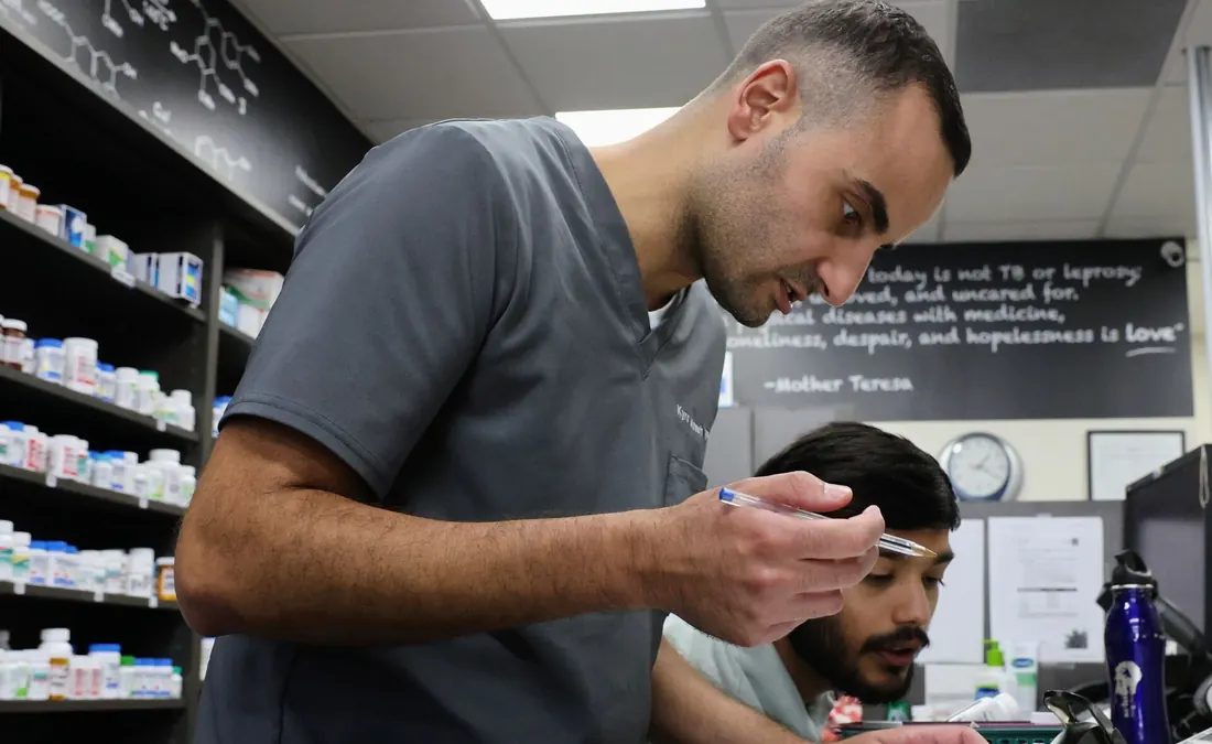 Pharmacist reviewing a patient's medication with two team members