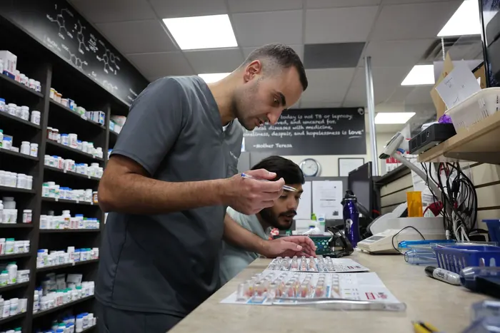 Pharmacist and pharmacy technician reviewing filled prescriptions at Lawlor Pharmasave